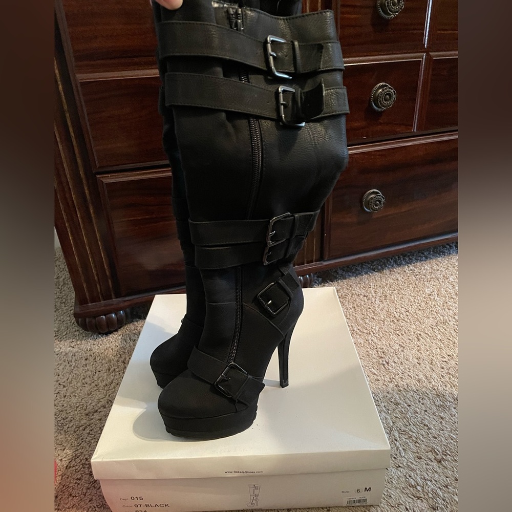 Black stiletto knee high leather boots with buckles.